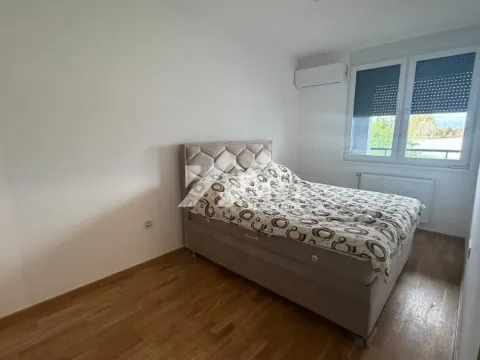 Furnished bedroom with a double bed and a window. - image 6