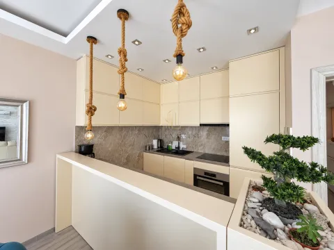 Modern kitchen with beige cabinets and built-in appliances. - image 5