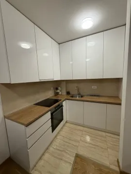Modern kitchen with white cabinets and a wooden countertop. - image 4