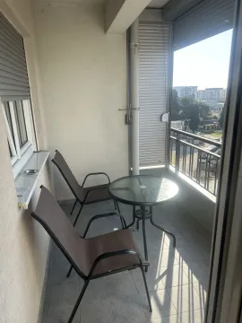 Balcony with two chairs and a round table. - image 5