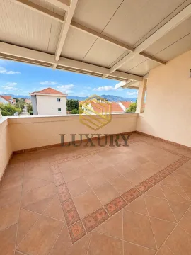 Spacious covered terrace with a view of the neighborhood and mountains. - image 2