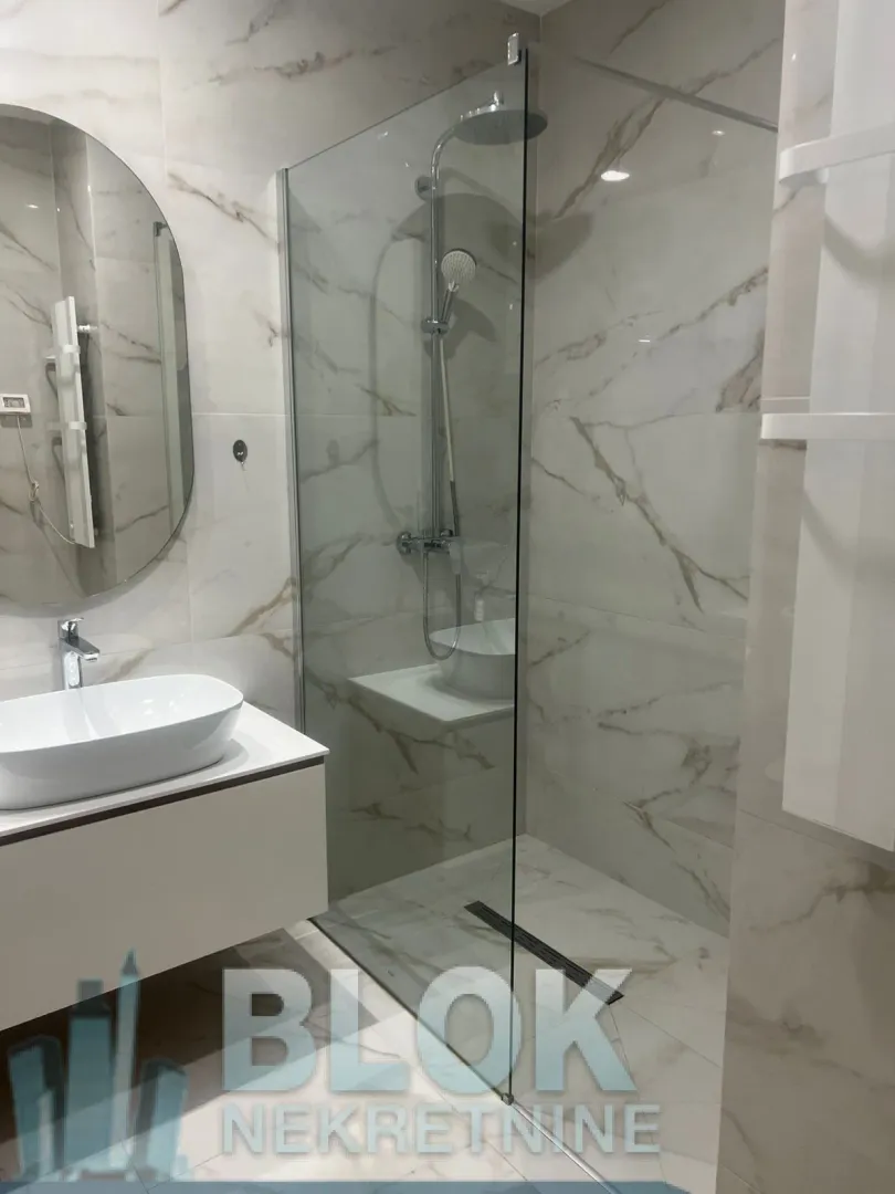 Modernly equipped bathroom with a walk-in shower and washbasin.