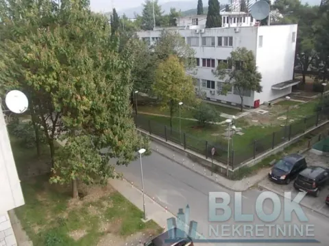 View from the terrace overlooking surrounding buildings, the street, and greenery. - image 6
