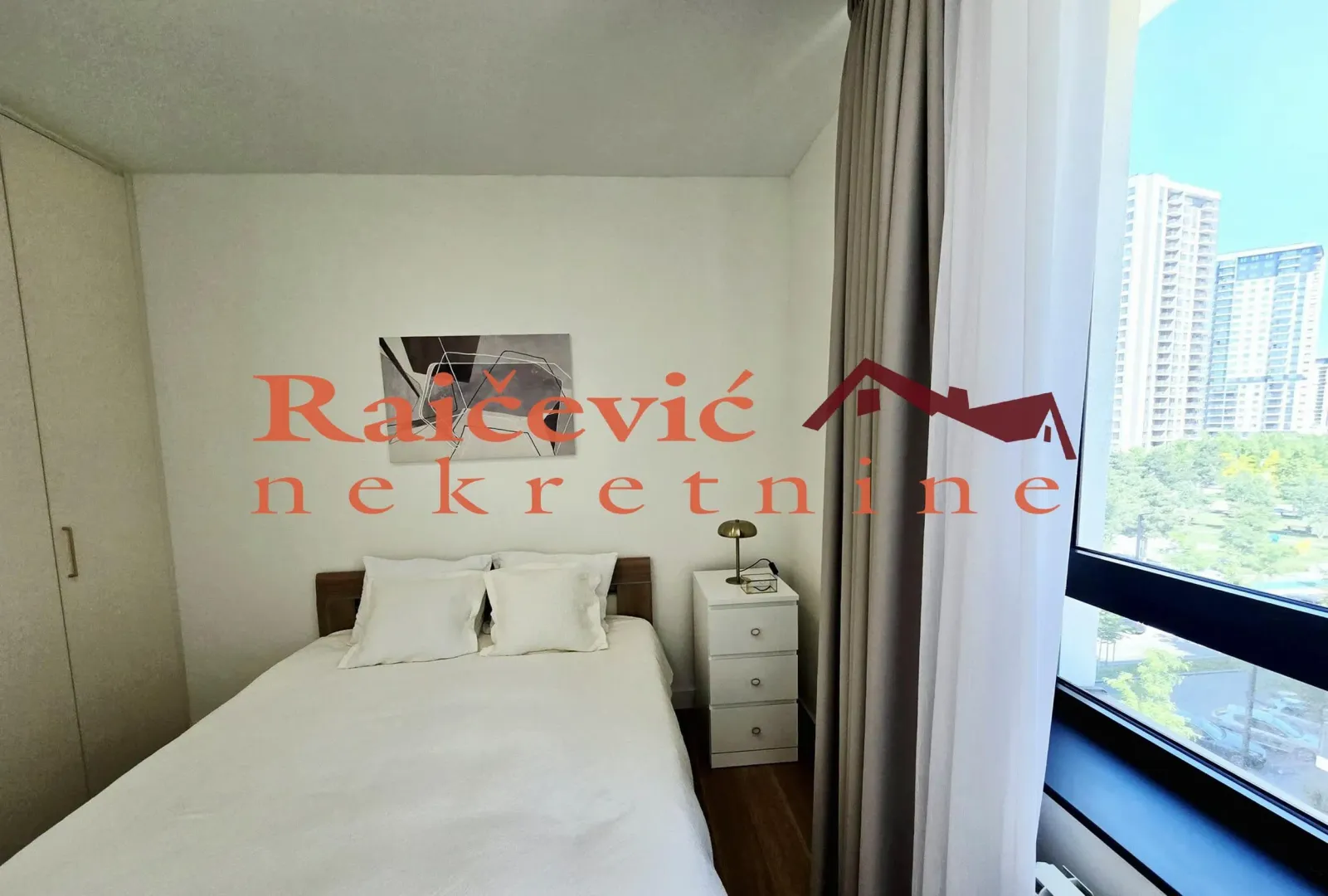 Furnished bedroom with a double bed and a window overlooking the city.