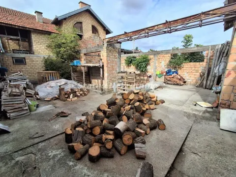 Dvorište kuće sa gomilom drva za ogrev i pomoćnim objektima u izgradnji. - image 6