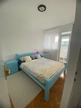 Spavaća soba sa plavim krevetom i noćnim stočićem, sa izlazom na terasu. - image 10