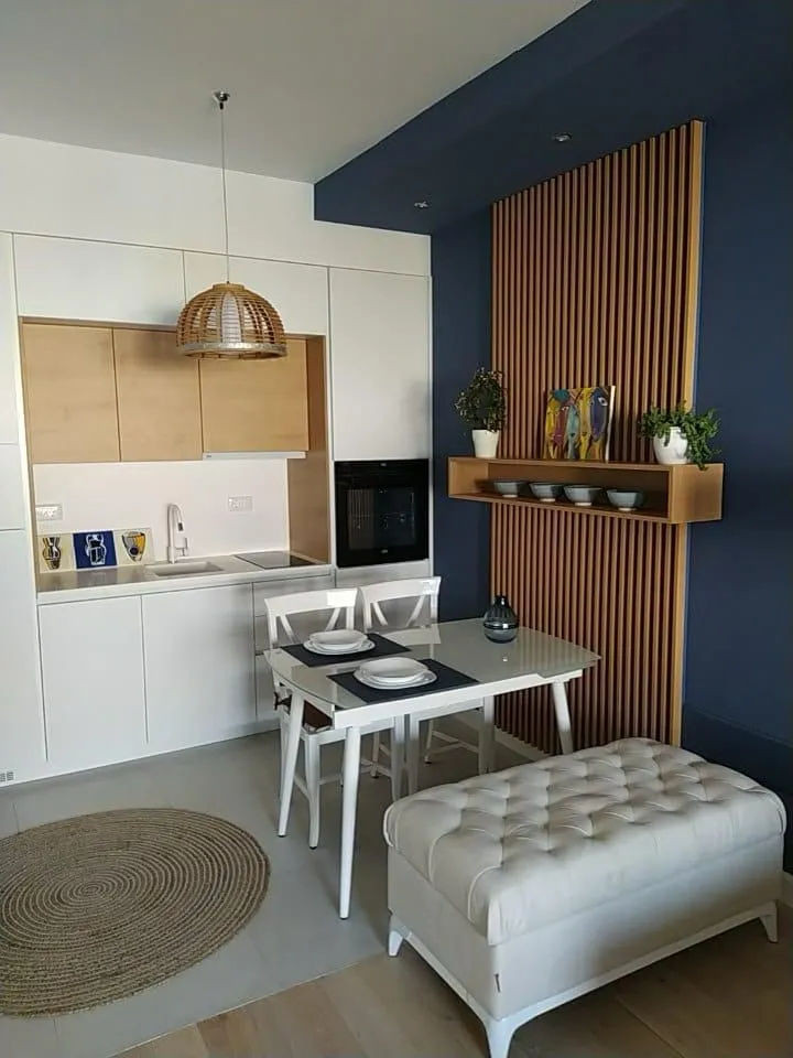 Modern kitchen with dining area and blue wall panel.