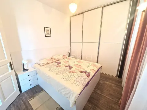 Namještena spavaća soba sa bračnim krevetom, bijelim garderoberom i noćnim stočićem. - image 7