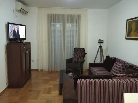 Dnevna soba sa garniturom, televizorom i drvenim podom. - image 2
