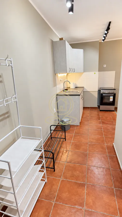 Small kitchen with a sink, cabinetry, and a stove.