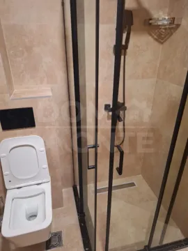 Modern bathroom with a shower cabin and a wall-hung toilet. - image 9