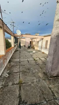 Prostrana krovna terasa zgrade sa stolom, stolicama i satelitskom antenom. - image 9