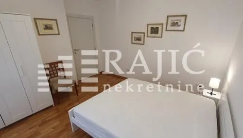 Furnished bedroom with a double bed, wardrobe, and framed pictures on the wall.