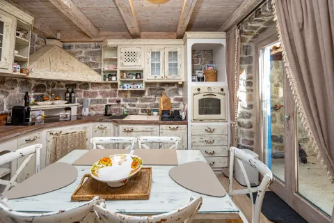 Rustic kitchen with wooden elements, stone walls, and a dining table. - image 5