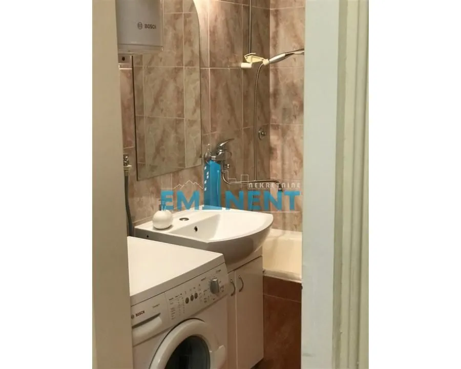 Smaller bathroom with a washbasin, washing machine and bathtub.