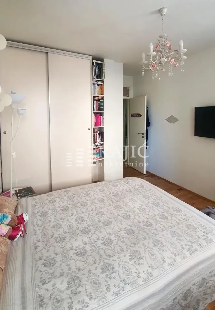 Furnished bedroom with a large double bed, wardrobe, and a chandelier.