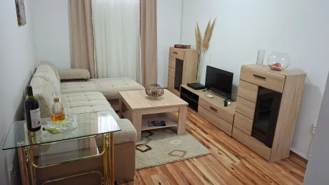 Living room with a sectional sofa, wooden furniture, and a television. - image 2