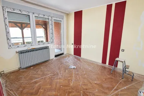 Prazna soba sa parketom, radijatorom i izlazom na terasu, pripremljena za renoviranje. - image 5
