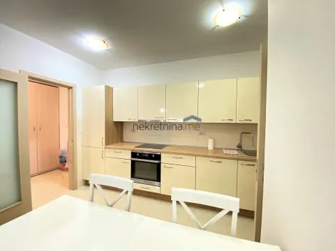 Modern kitchen with white cabinets and a dining table. - image 2
