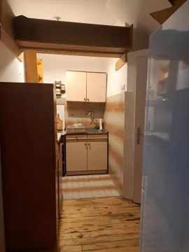 Small kitchen with a sink, cabinets, and wooden flooring. - image 3
