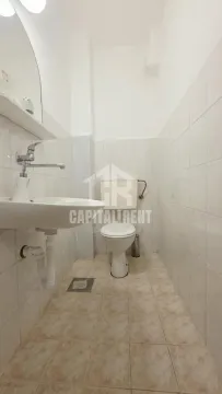 Small bathroom with a sink and toilet in white tiles. - image 5