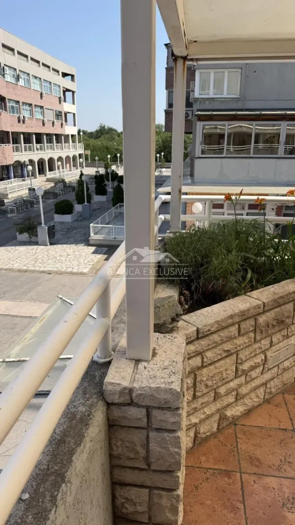 Pogled sa terase na popločani trg i okolne zgrade.