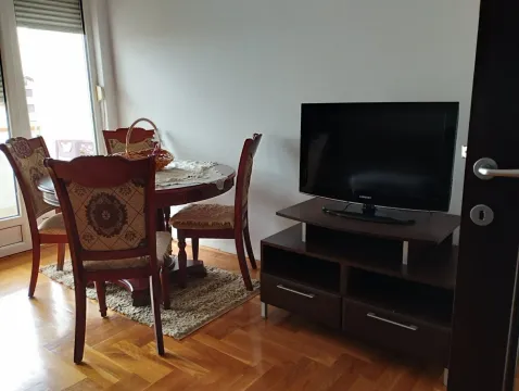 Trpezarijski sto sa stolicama i TV komoda u dnevnoj sobi. - image 17