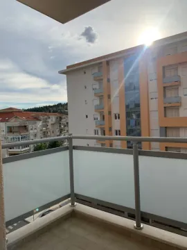 View from a balcony looking towards an adjacent apartment building under a sunny sky. - image 3