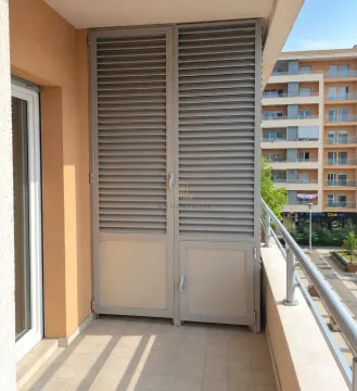 Covered balcony with a closed storage cabinet and view of the neighborhood. - image 5