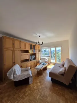 Dnevna soba sa garniturom, drvenim nameštajem i izlazom na balkon. - image 2