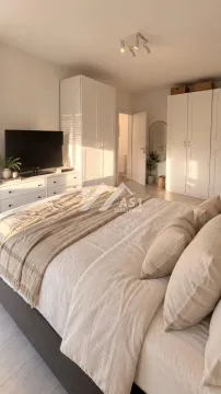 Spacious bedroom with a double bed, wardrobes, and a TV. - image 5