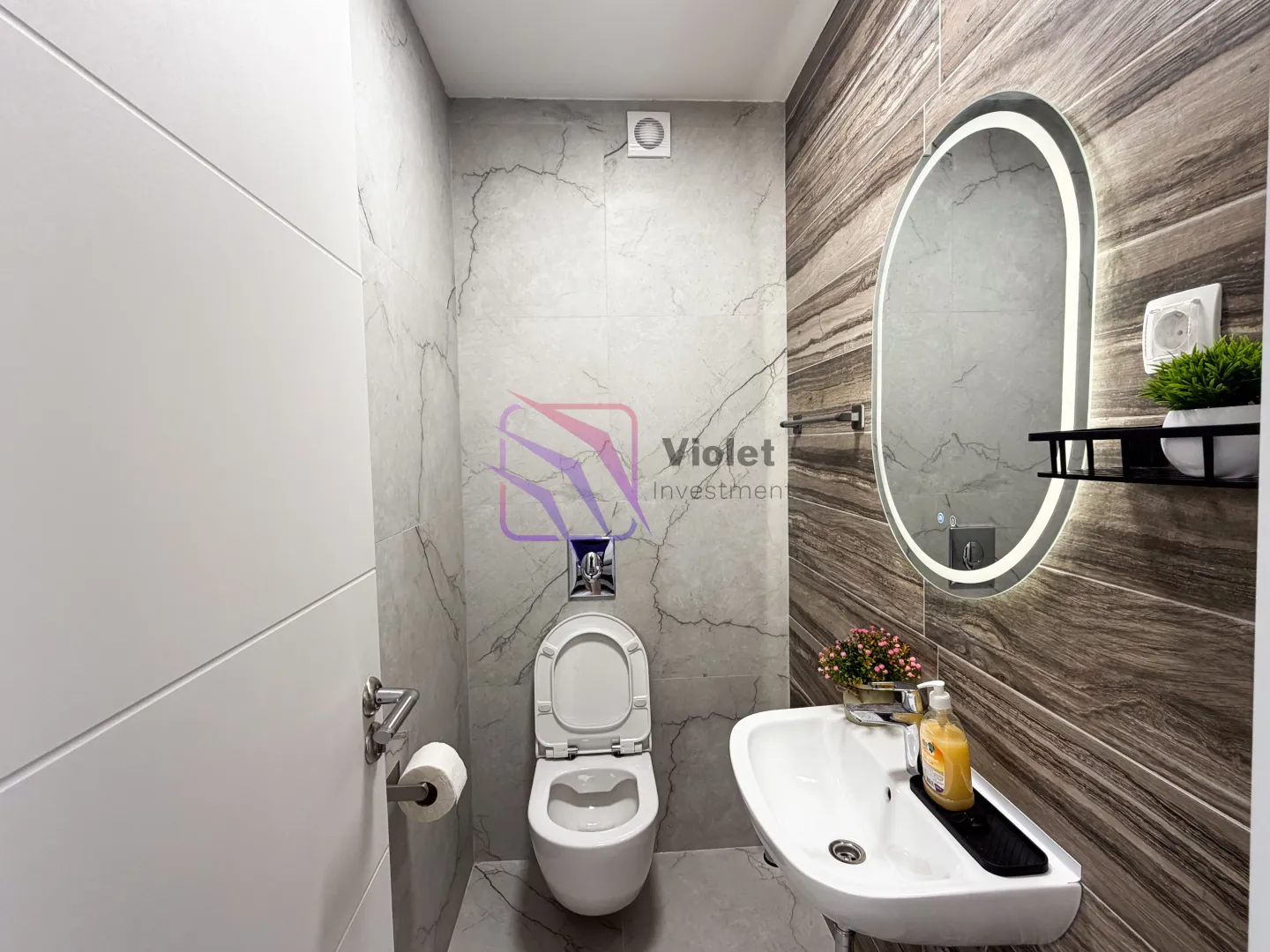 Moderno opremljeno kupatilo sa umivaonikom i wc šoljom.