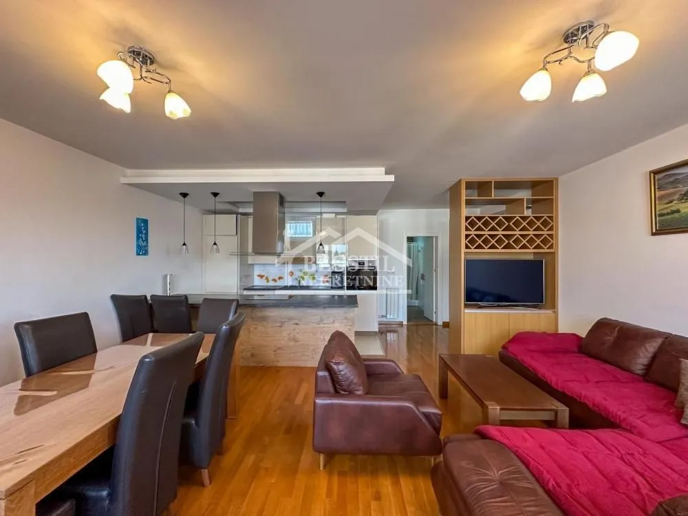 Living room with a dining area and an open kitchen.