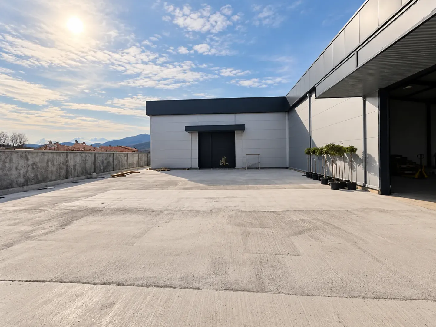 Exterior of the commercial building with a concrete yard and surrounding view.