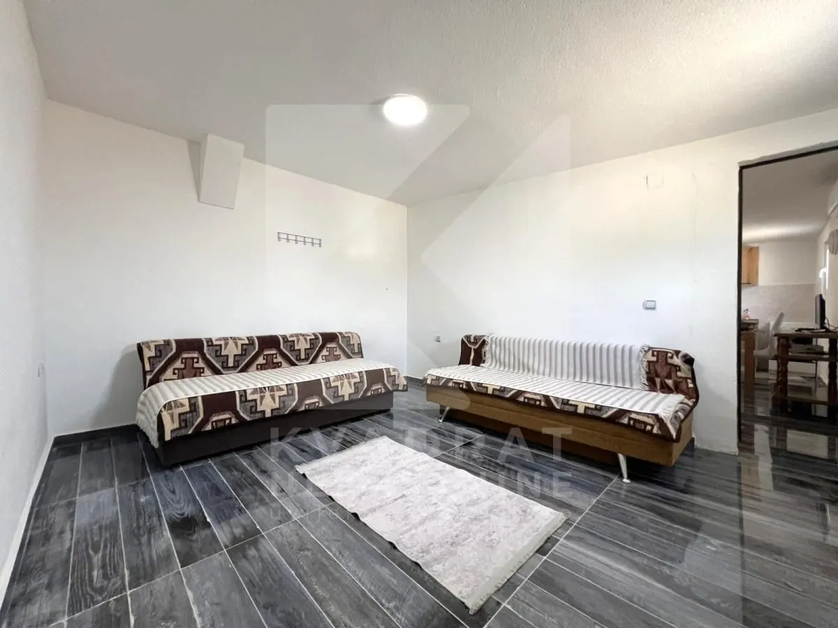 Living room with two sofas and dark flooring.
