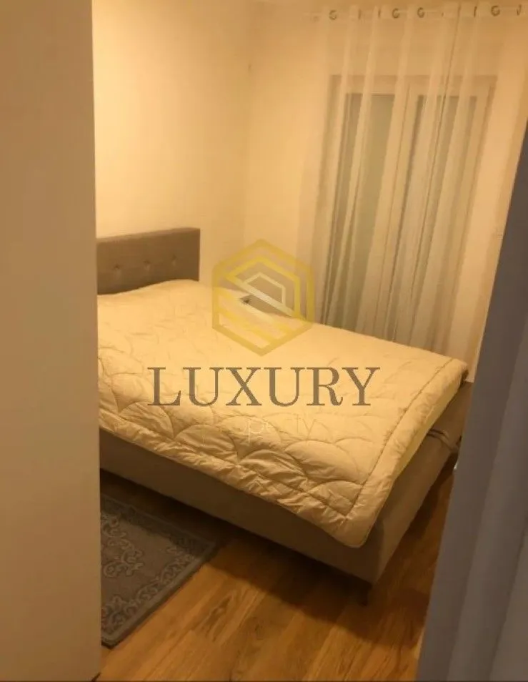 Furnished bedroom with a double bed and a window.