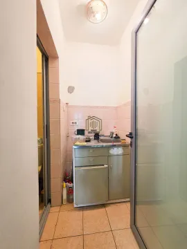 Small kitchenette with a sink and cabinets. - image 10