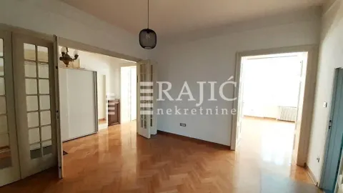 Empty room with parquet flooring and wooden double doors. - image 3