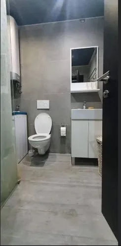 Moderne opremljeno kupatilo sa tuš kabinom, umivaonikom i wc šoljom.