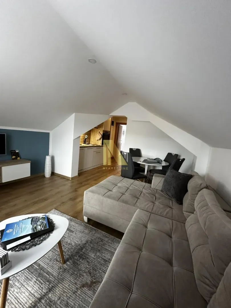 Spacious living room with a sofa and dining area in the attic.