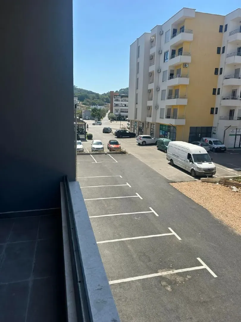 Pogled sa terase na parking i okolne zgrade.