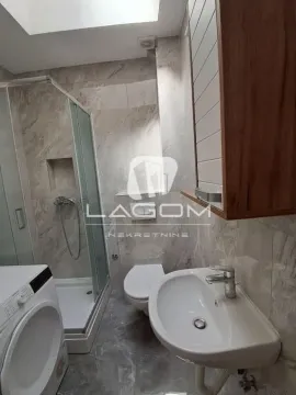 Moderno opremljeno kupatilo sa tuš kabinom, umivaonikom i veš mašinom. - image 10