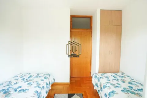 Bedroom with two single beds and a fitted wardrobe. - image 7