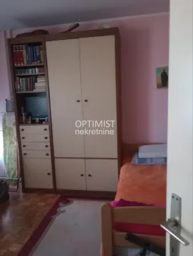 Manja spavaća soba sa krevetom i garderoberom sa policama za knjige. - image 2