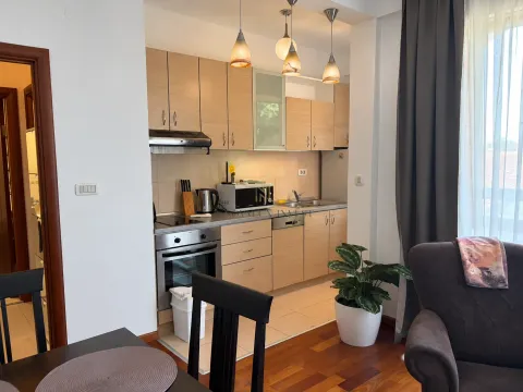 Small kitchen with wooden cabinetry and built-in appliances. - image 4