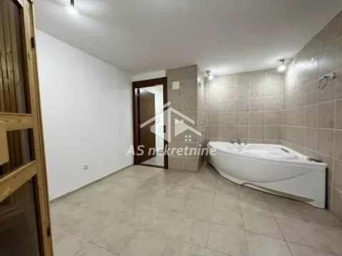 Kupatilo opremljeno ugaonom kadom i pločicama na zidu i podu. - image 23