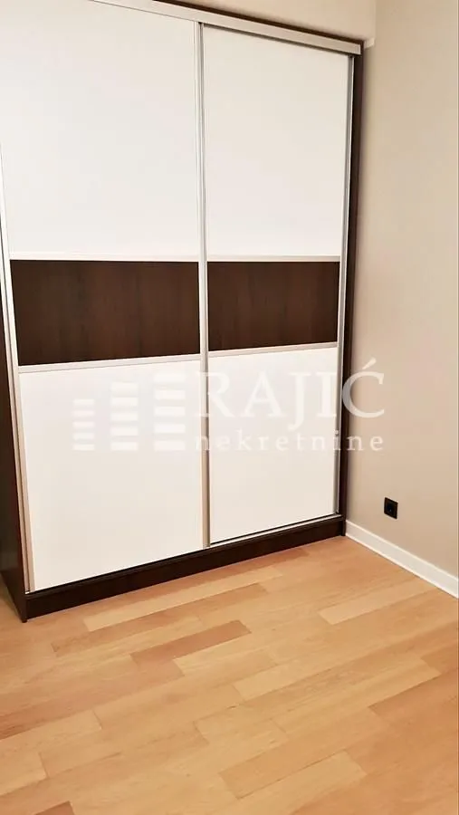 Bedroom with a large built-in wardrobe and wooden flooring.