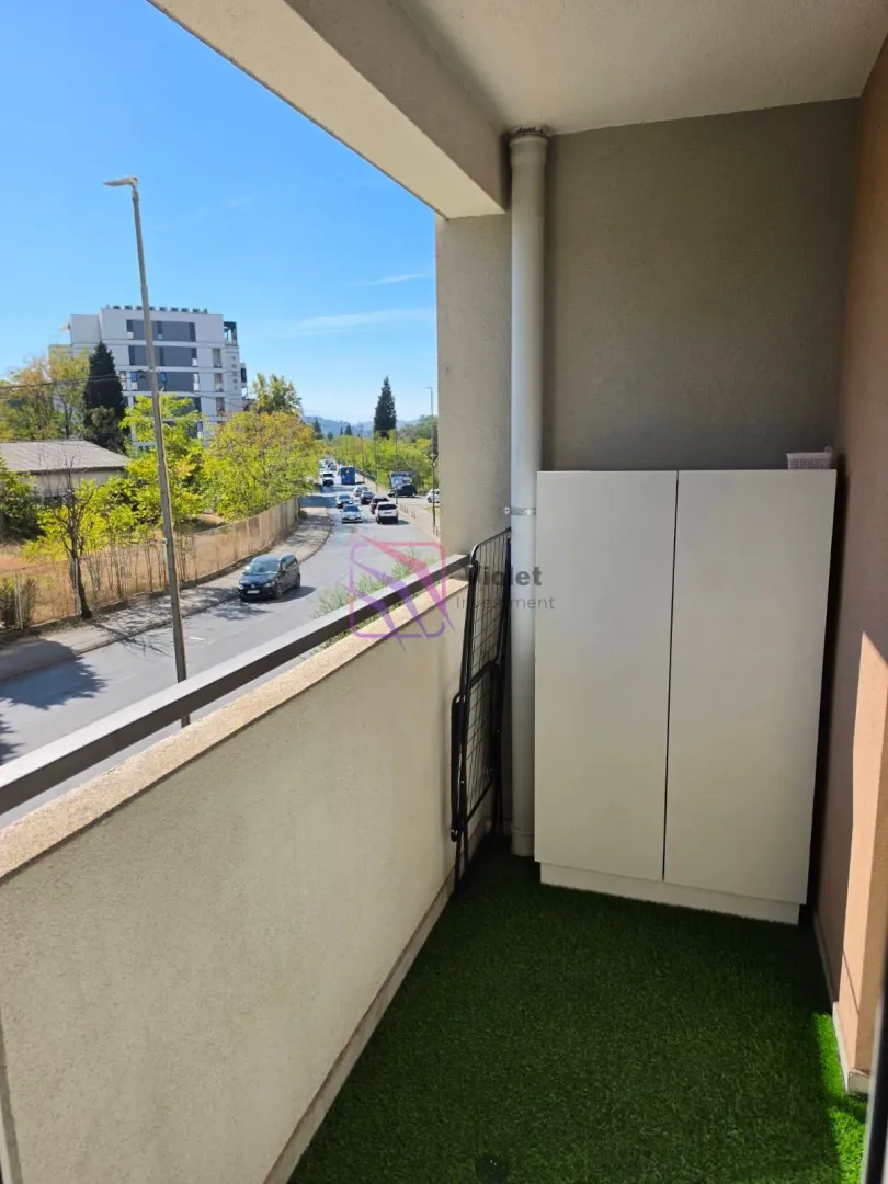 Manji natkriveni balkon sa ormarićem i pogledom na ulicu.