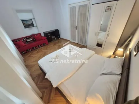 Furnished bedroom with a double bed, wardrobe, and sofa. - image 13