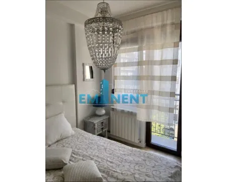 Bedroom with a bed, a nightstand, and a large chandelier. - image 8